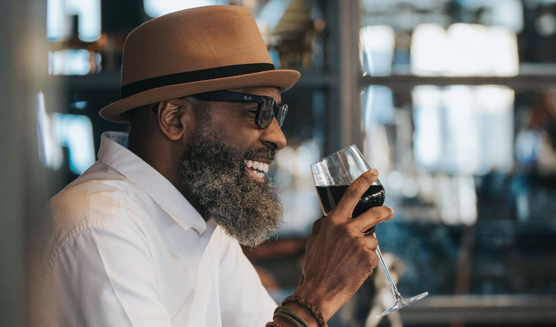 man sitting with a glass of wine in his hand