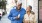 older couple walks down city sidewalk while holding ice cream cones